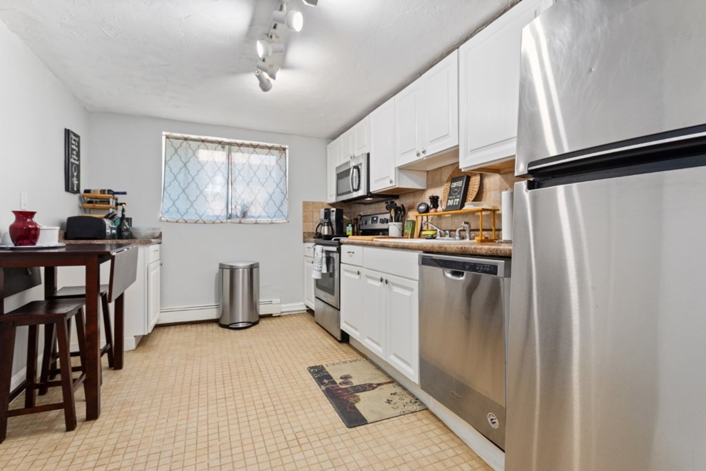 68 Bryon Road, Unit 2 Boston, MA 02467 - Photo 4 of 18 a kitchen with stainless steel appliances granite countertop a sink stove and refrigerator