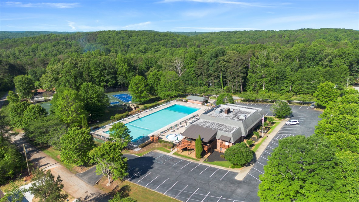 118 Choestoea Road Westminster, SC 29693 - Photo 1 of 8 An aerial perspective reveals a serene community pool with tennis courts, nestled amidst a lush forest landscape.