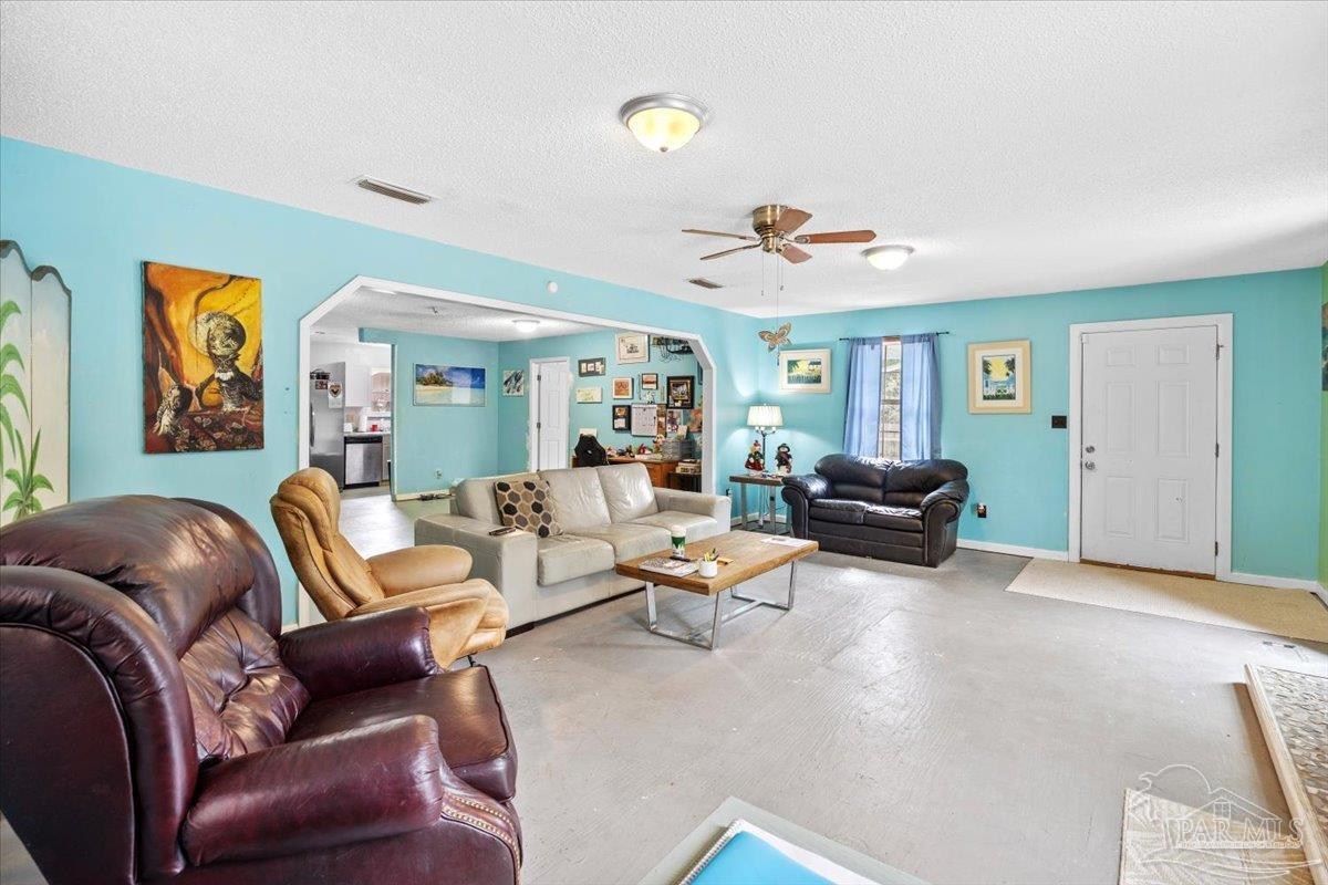 3060 Safronia Shores Road Navarre, FL 32566 - Photo 12 of 28 a living room with furniture and a chandelier