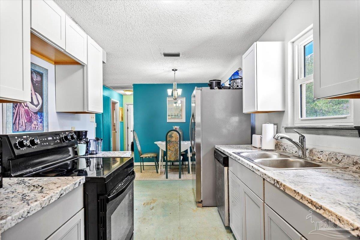 3060 Safronia Shores Road Navarre, FL 32566 - Photo 13 of 28 a kitchen with a stove sink and cabinets