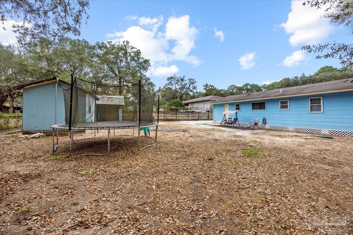 3060 Safronia Shores Road Navarre, FL 32566 - Photo 24 of 28 a backyard of a house with table and chairs