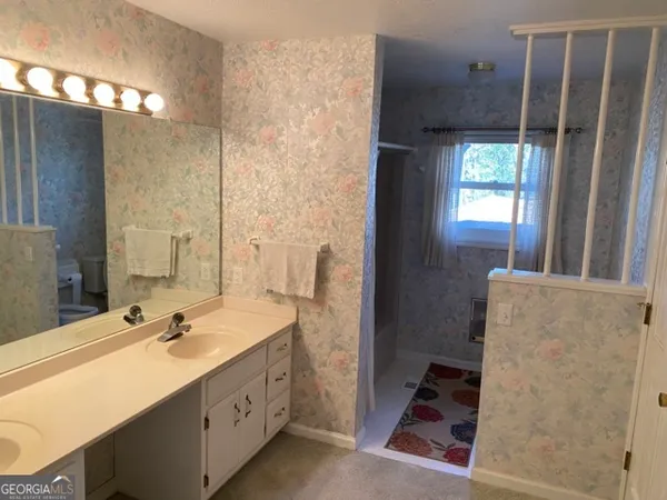 a bathroom with a double vanity sink a mirror and a shower