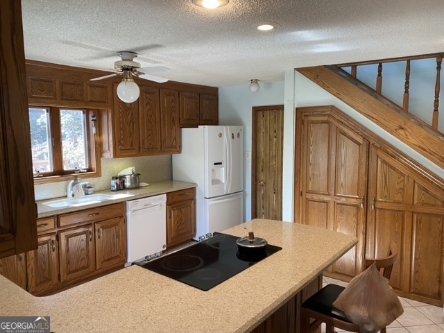 373 Western Way Rabun Gap, GA 30568 - Photo 10 of 30 a kitchen with a refrigerator a stove sink and cabinets