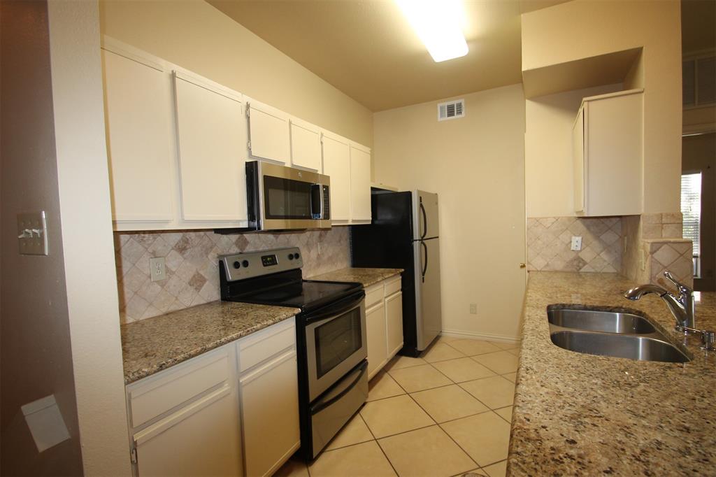 2524 Preston Road, Unit 1203 Plano, TX 75093 - Photo 5 of 30 a kitchen with granite countertop a sink a stove top oven and refrigerator