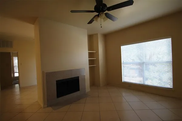 a view of an empty room with a fireplace and a window
