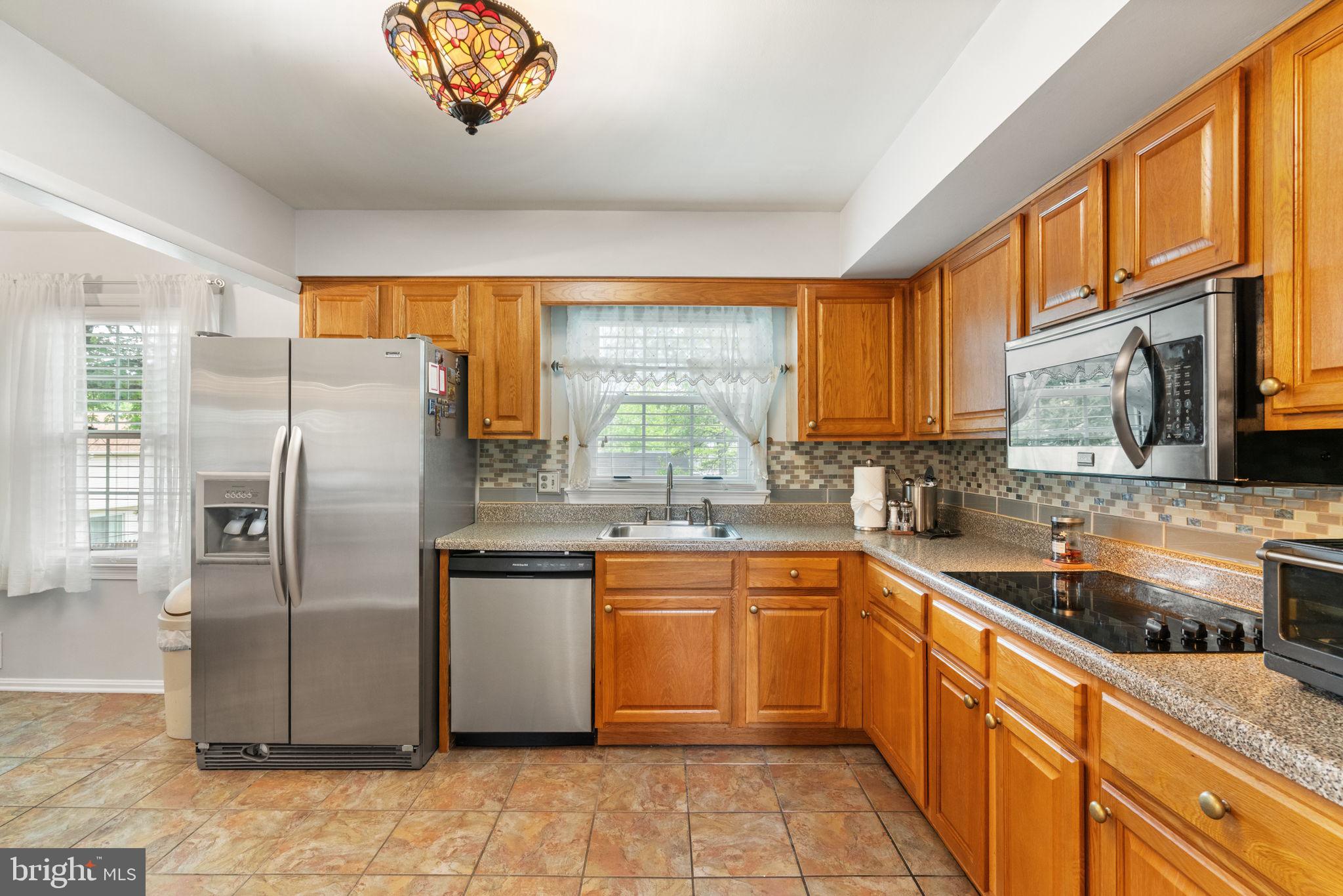 7610 Bland Drive Manassas, VA 20109 - Photo 11 of 43 a kitchen with stainless steel appliances granite countertop a sink a stove and refrigerator