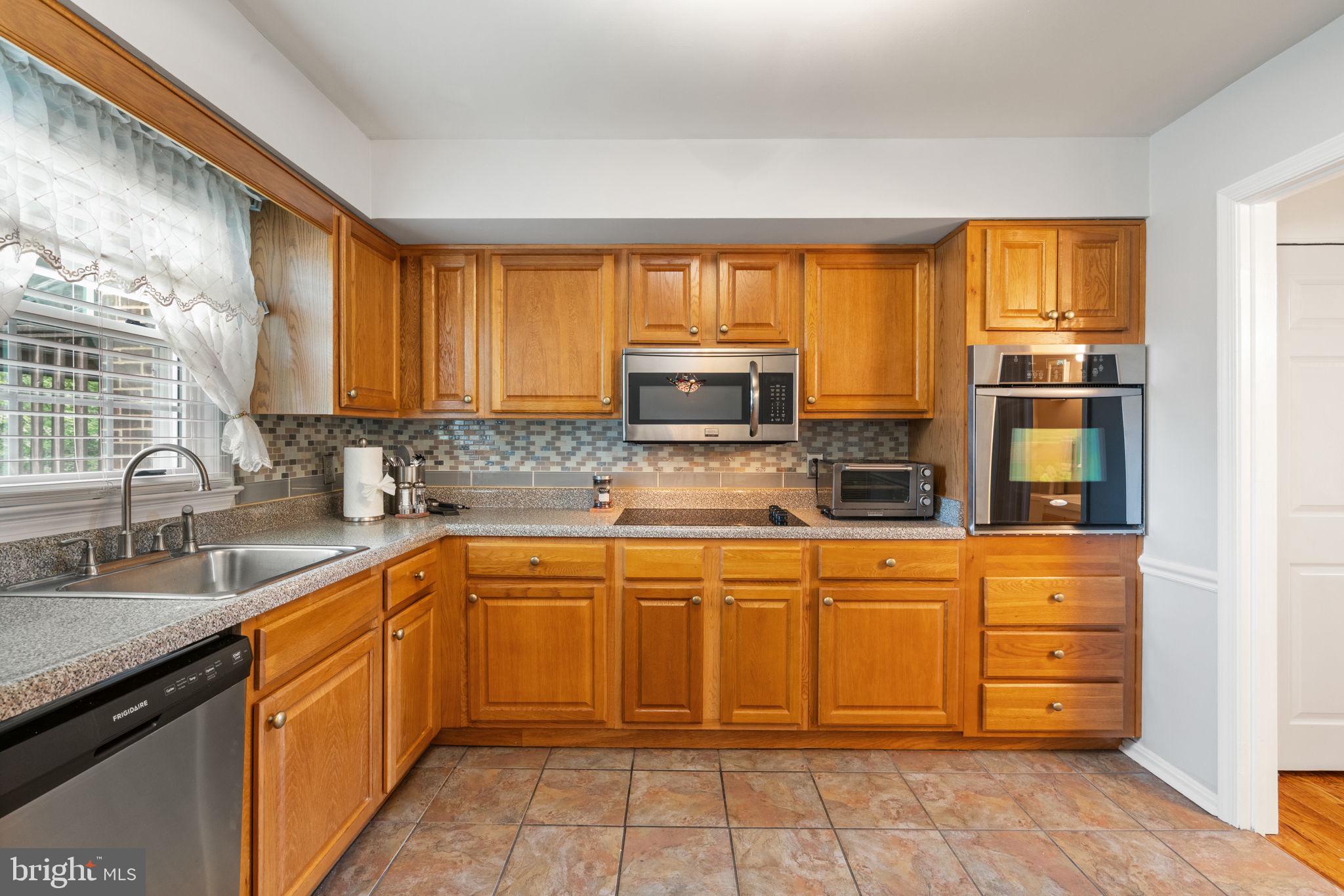 7610 Bland Drive Manassas, VA 20109 - Photo 12 of 43 a kitchen with stainless steel appliances granite countertop a stove sink and microwave