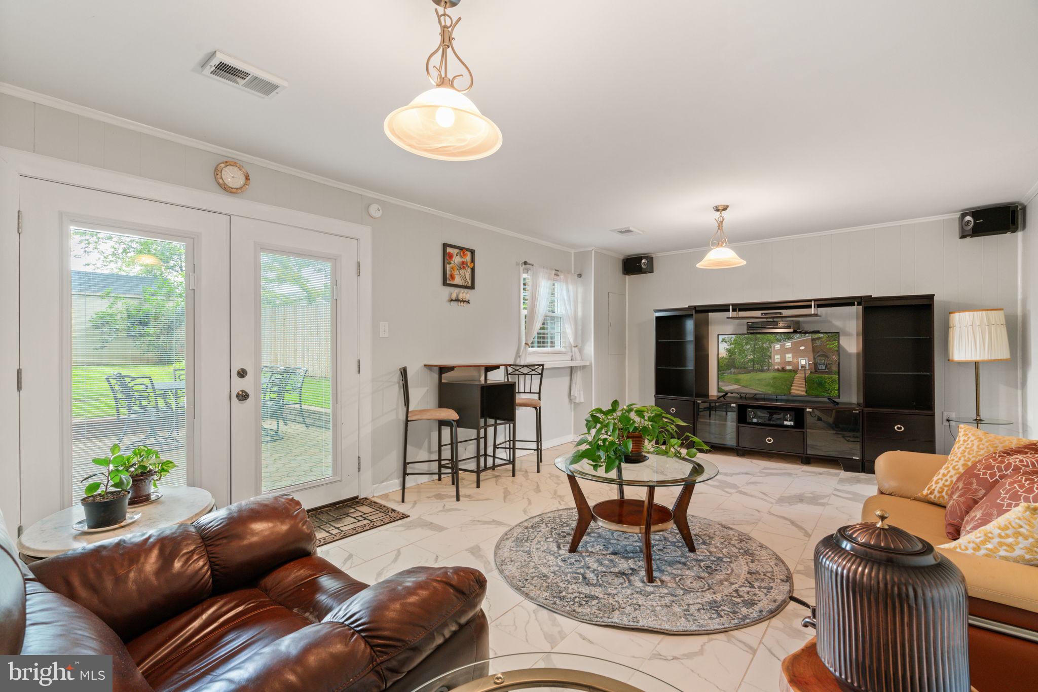 7610 Bland Drive Manassas, VA 20109 - Photo 26 of 43 a living room with furniture a chandelier and a flat screen tv
