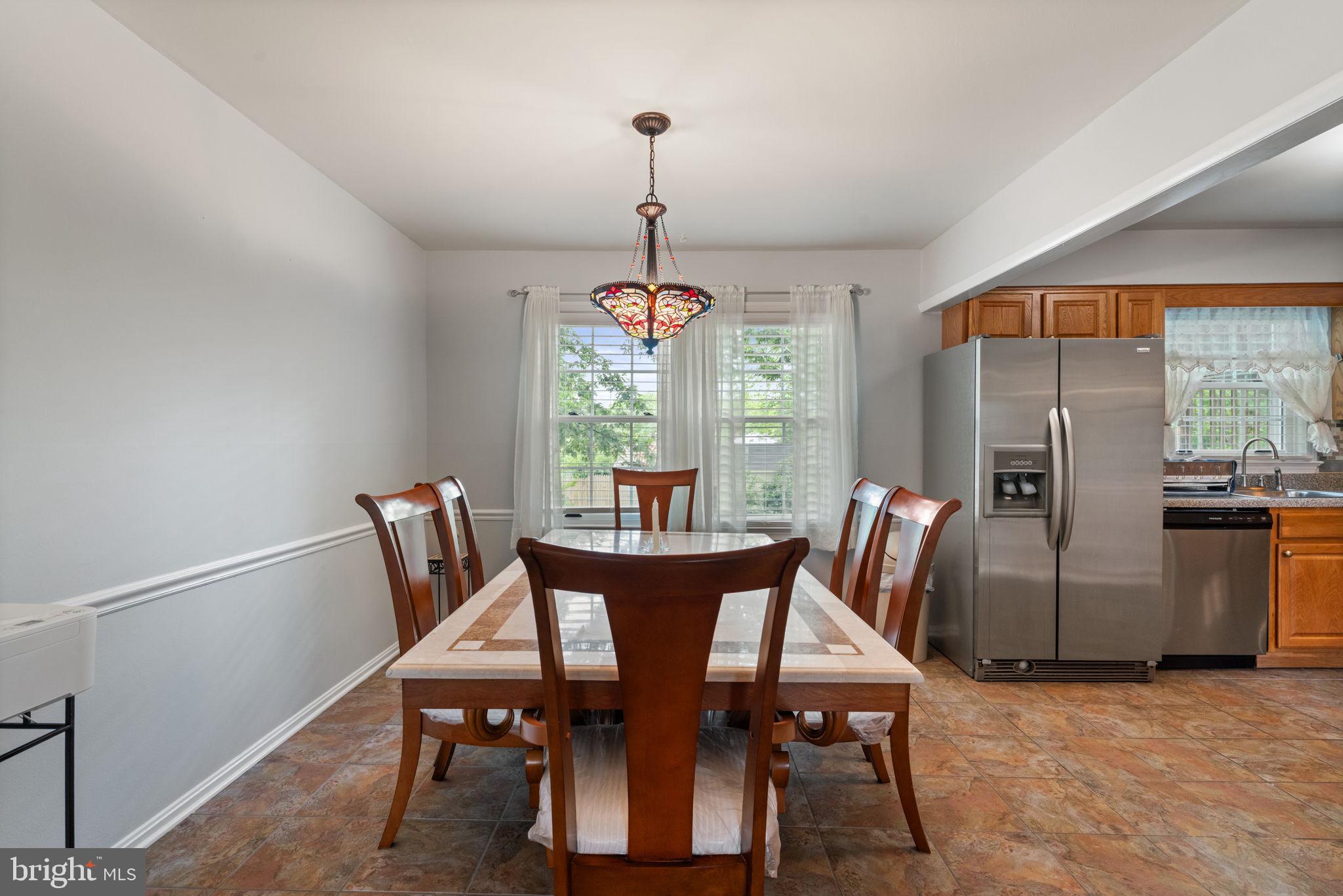 7610 Bland Drive Manassas, VA 20109 - Photo 8 of 43 a dining room with furniture a chandelier and wooden floor