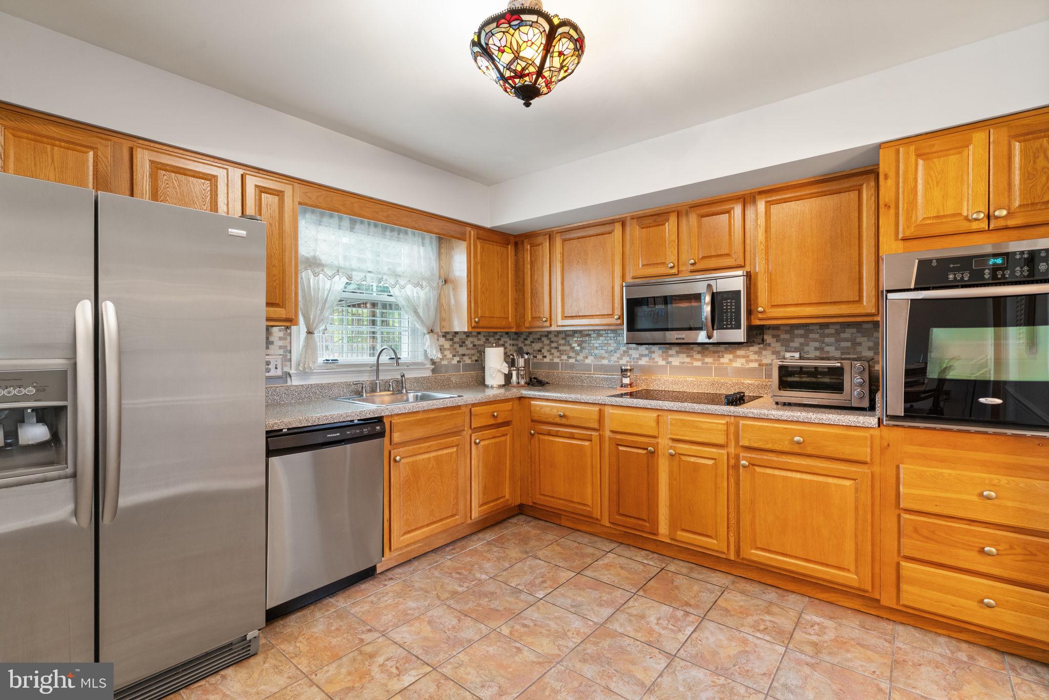 7610 Bland Drive Manassas, VA 20109 - Photo 10 of 43 a kitchen with stainless steel appliances granite countertop a refrigerator a stove a sink and a microwave