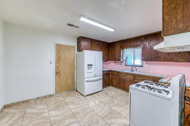 a kitchen with stainless steel appliances granite countertop a refrigerator sink and stove