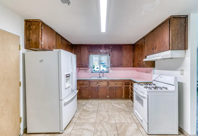 a bathroom with a granite countertop sink toilet and mirror