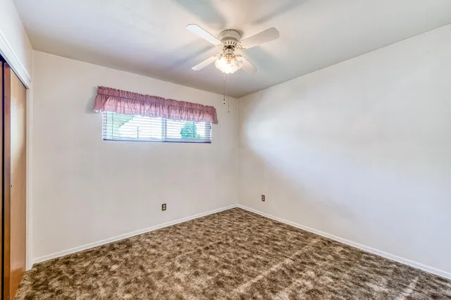 a view of a livingroom with a ceiling fan and window