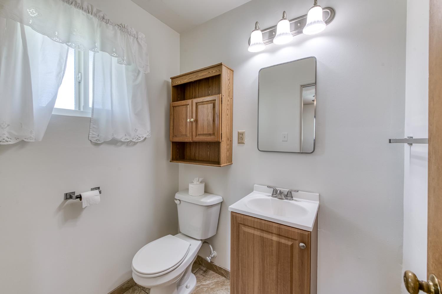 8625 La Vaca Way Hanford, CA 93230 - Photo 22 of 33 a bathroom with a toilet a sink and mirror