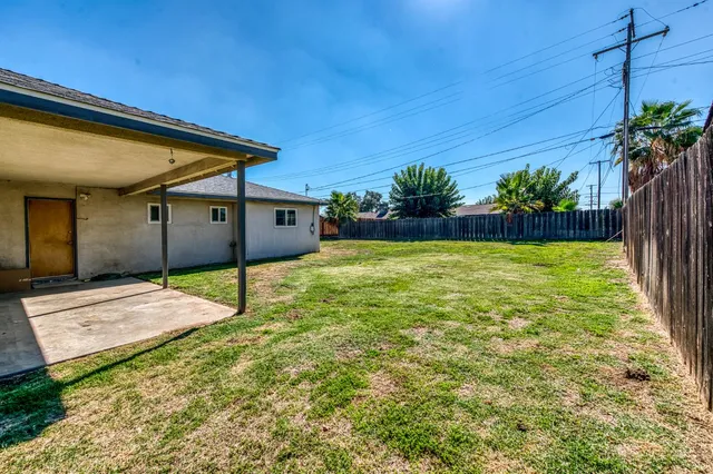 a view of backyard with wooden fence and flowers