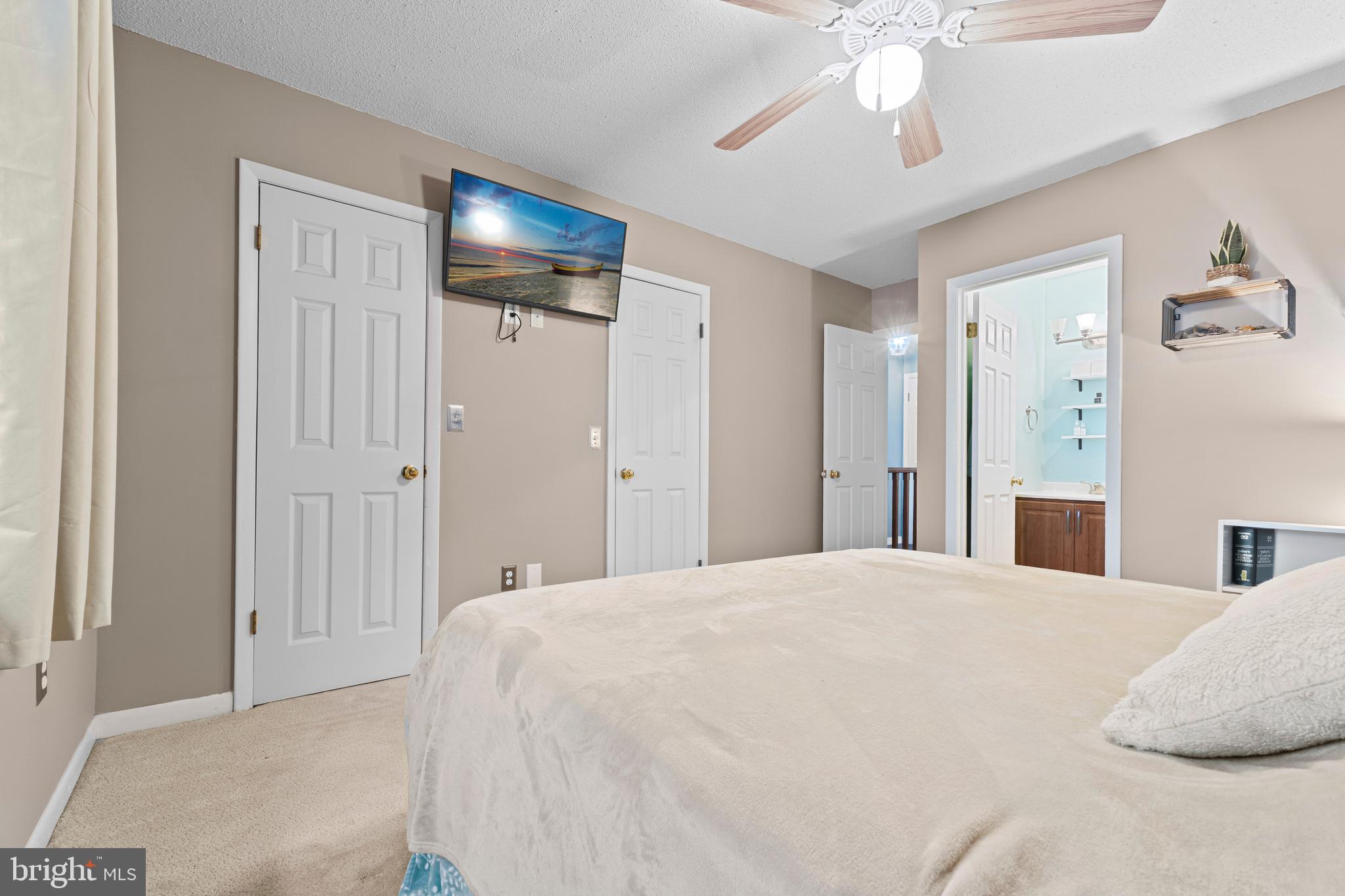 9815 Stephen Decatur Highway, Unit 14 Ocean City, MD 21842 - Photo 24 of 30 a spacious bedroom with a bed and a chandelier