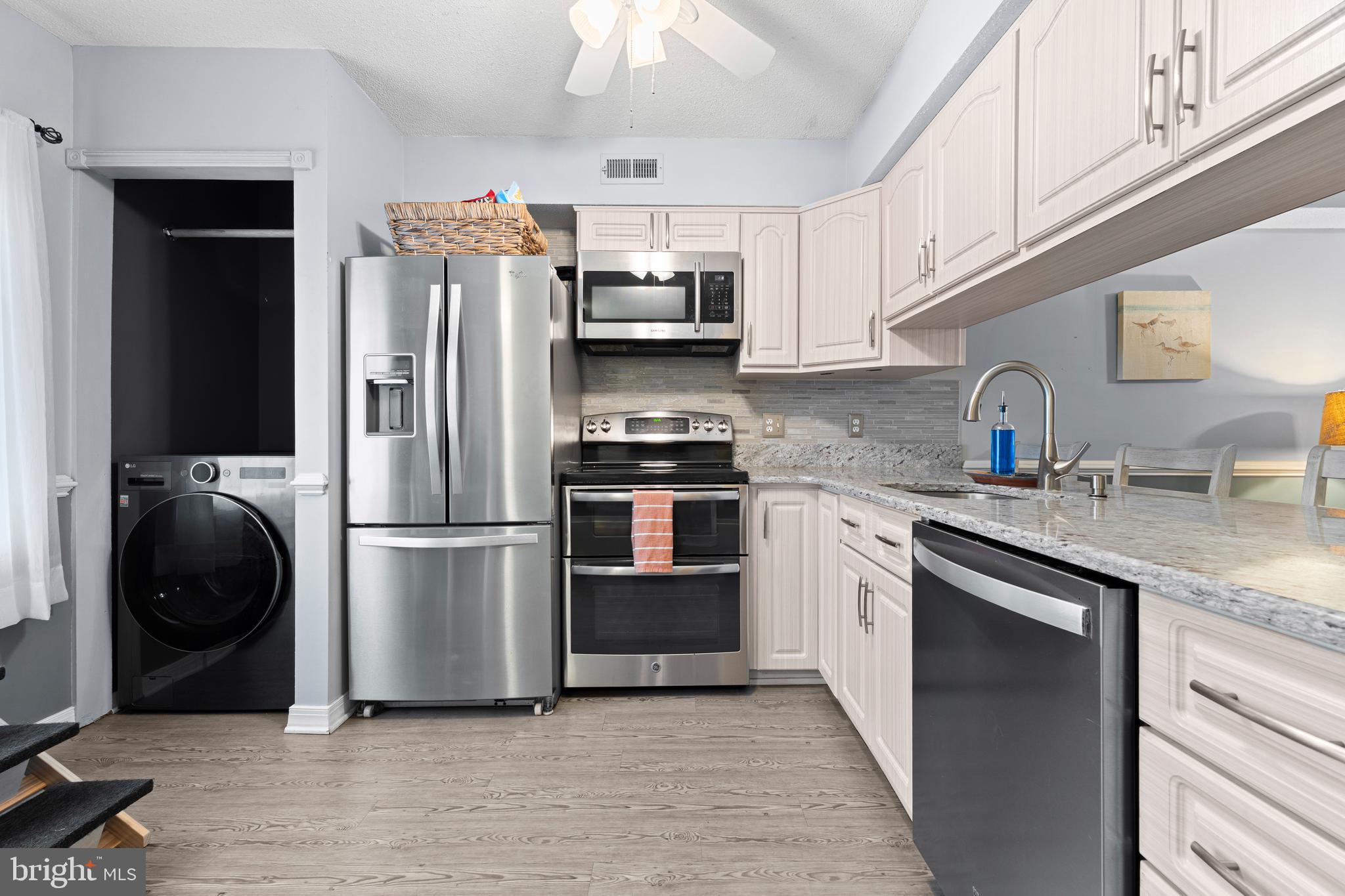 9815 Stephen Decatur Highway, Unit 14 Ocean City, MD 21842 - Photo 4 of 30 a kitchen with stainless steel appliances granite countertop a refrigerator sink and stove