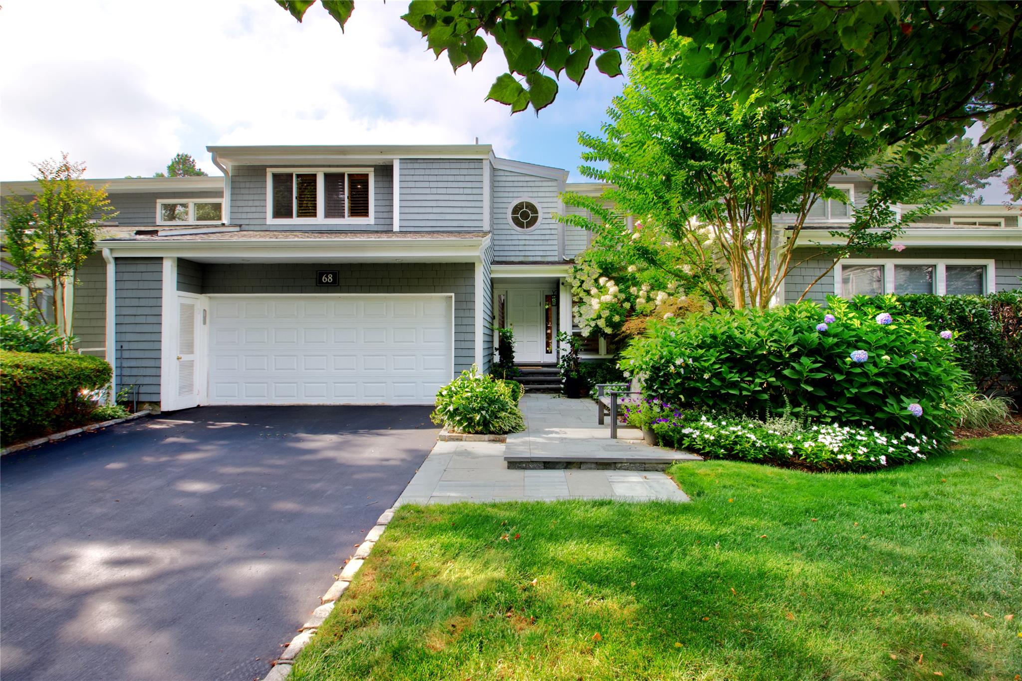 68 Bond Court Manhasset, NY 11030 - Photo 1 of 1 a front view of a house with a garden