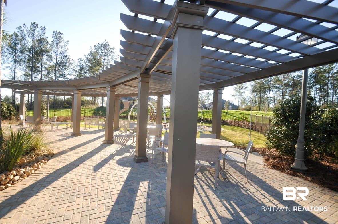 32125 Lyon Road Daphne, AL 36527 - Photo 54 of 70 Extensive outdoor pergola structure with multiple columns, featuring a herringbone pattern paver patio