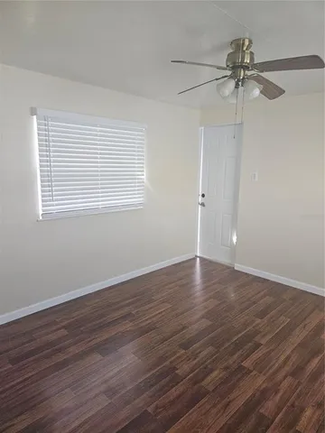 a view of a room with wooden floor and a window