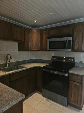 a kitchen with sink microwave and cabinets