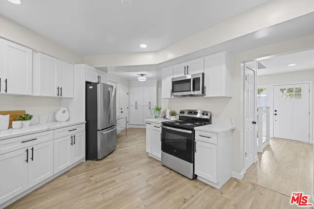 a kitchen with a refrigerator stove and wooden cabinets