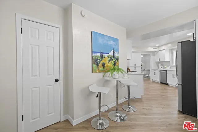 a kitchen with stainless steel appliances kitchen island granite countertop a refrigerator and a sink