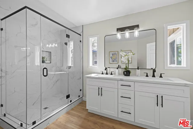 a bathroom with a double vanity sink mirror and shower
