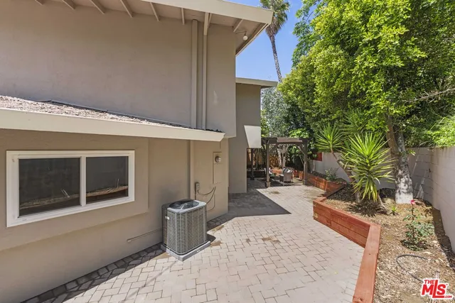a patio with table and chairs and potted plants