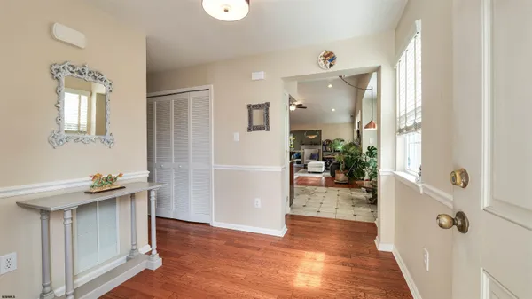 a living room with furniture kitchen view and a wooden floor