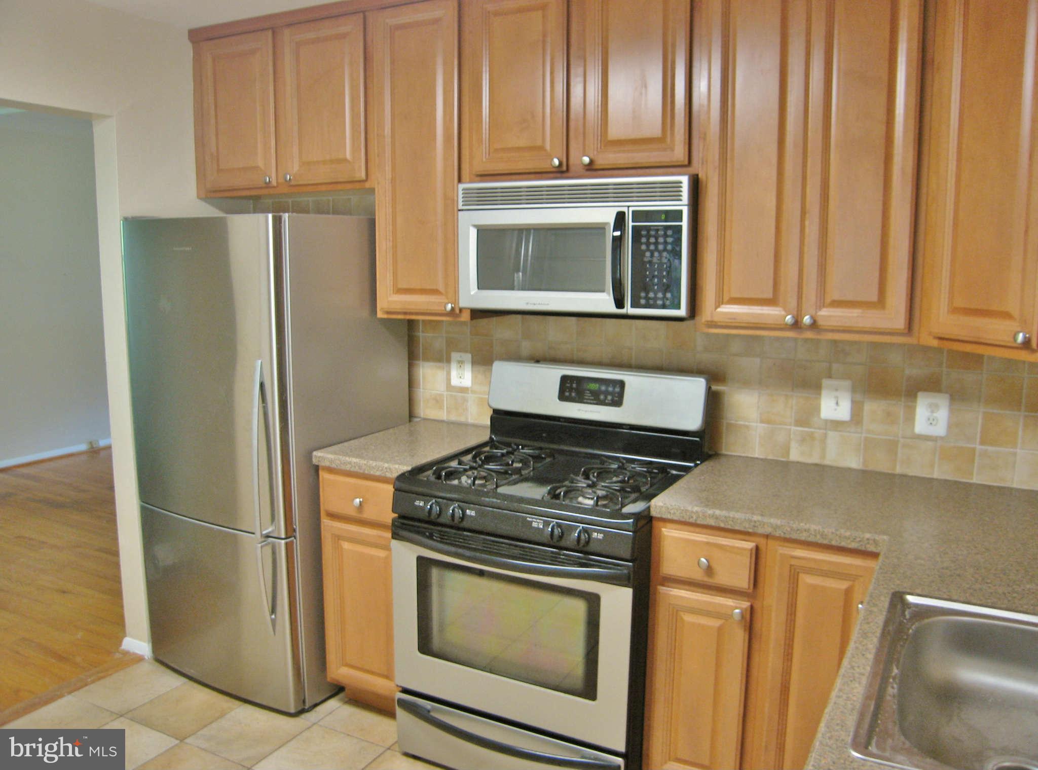 8113 Karl Road Alexandria, VA 22308 - Photo 5 of 15 a kitchen with granite countertop wooden cabinets and stainless steel appliances