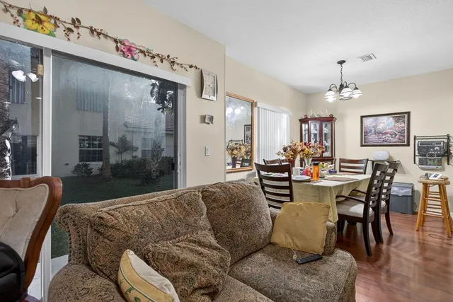 a living room with furniture a chandelier and a dining room