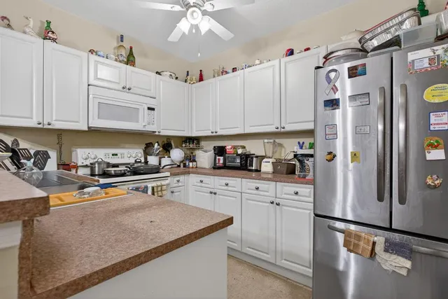 a kitchen with stainless steel appliances granite countertop a refrigerator sink and cabinets