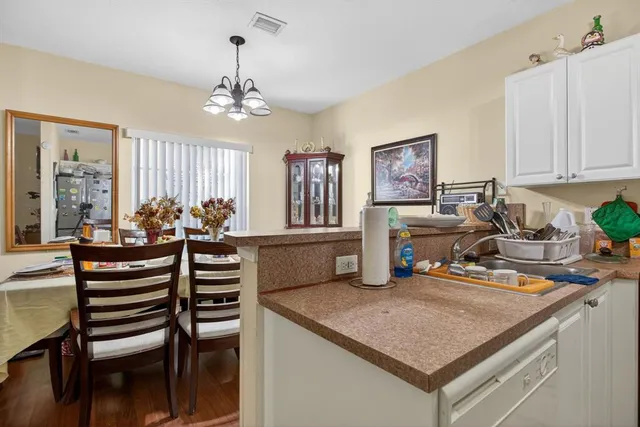 a kitchen with a table chairs and white cabinets