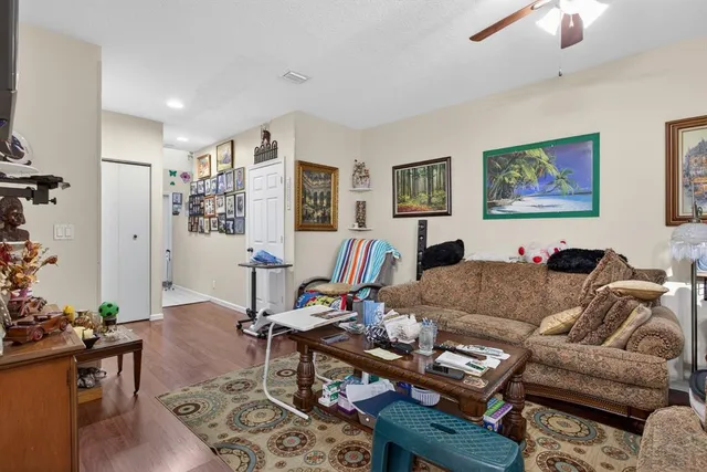 a living room with furniture a flat screen tv and a dining table