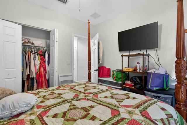a bedroom with bed and a flat screen tv