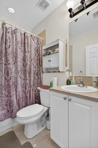 a bathroom with a toilet a sink a mirror a shower and vanity