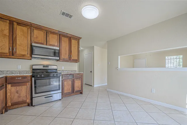 a kitchen with stainless steel appliances granite countertop a stove and a microwave