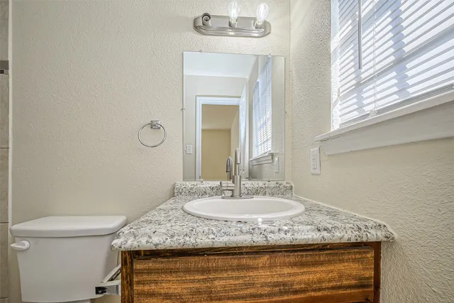 a bathroom with a granite countertop sink and a mirror