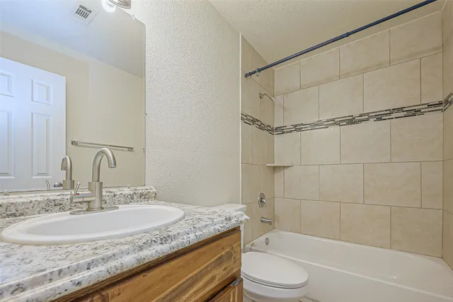 a bathroom with a granite countertop sink toilet and shower