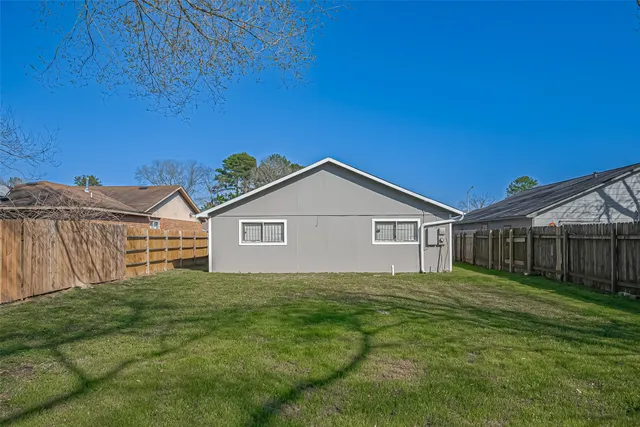 a view of a house with a yard and fence