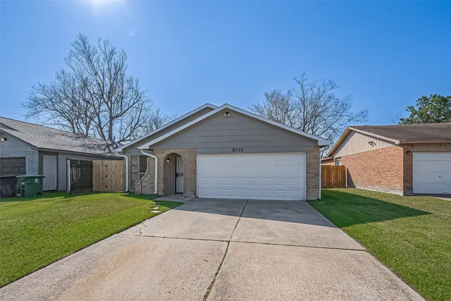 a front view of house with yard and trees all around
