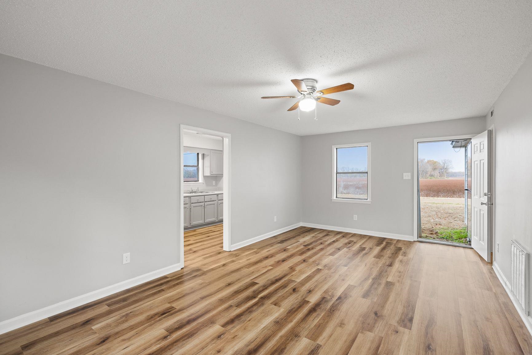 267 Ervin Lane Covington, TN 38019 - Photo 5 of 23 a view of an empty room with a window and wooden floor