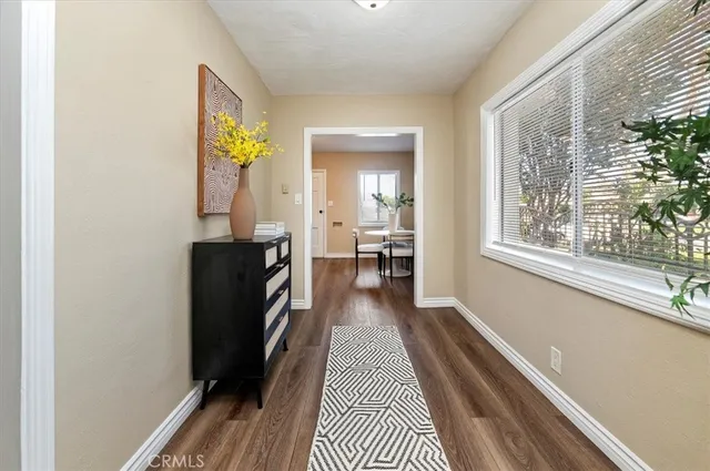 a view of a hallway with wooden floor and a window