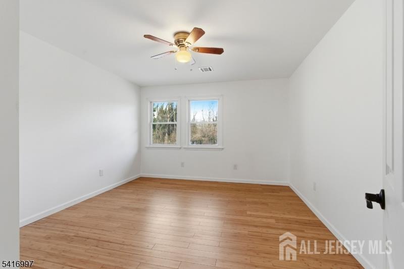 2 Rossi Drive Clinton, NJ 08809 - Photo 28 of 73 an empty room with wooden floor chandelier fan and windows
