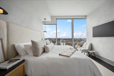 a bedroom with a bed and a flat tv screen on a dresser