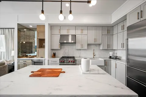 a kitchen with stainless steel appliances granite countertop a sink a stove and a refrigerator