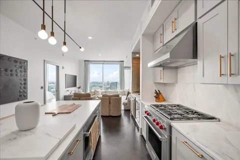 a kitchen with stove a sink dishwasher and a refrigerator with wooden floor