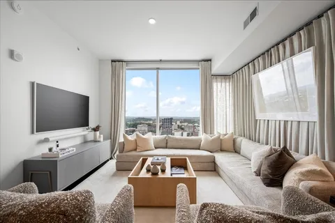 a living room with furniture large window and a flat screen tv