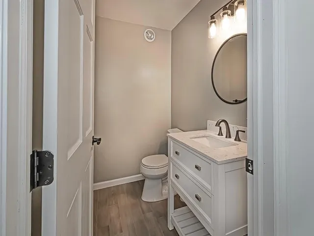 a bathroom with a toilet sink and mirror